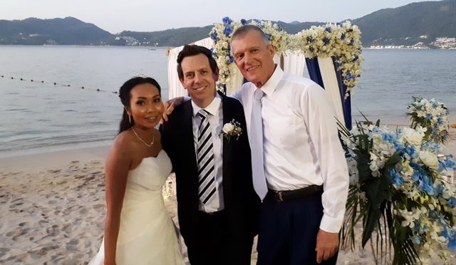 Phuket beach wedding couple standing with celebrant Peter Notley