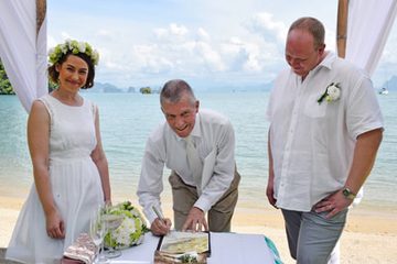 Wedding couple signing a ceremonial certificate with Peter Notley