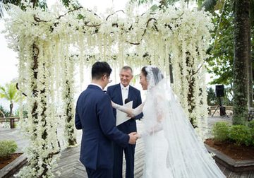 Wedding ceremony beneath white hanging flowers at a Phuket venue